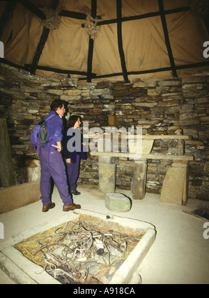 dh Replica SKARA BRAE ORKNEY Ecosse couple réplique de préhistorique maison néolithique touristes bronze âge foyer personnes modèle reconstruction grande-bretagne Banque D'Images