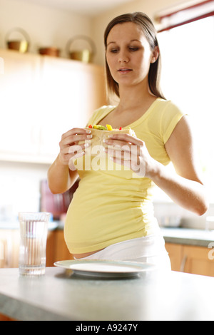 Pregnant woman eating sandwich Banque D'Images