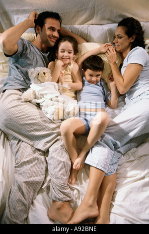 High angle view of parents allongé sur un lit avec leur fils et fille Banque D'Images