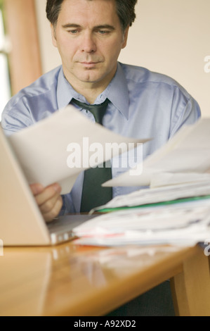 La fin de la quarantaine caucasien homme businessman avec pile de paperasse Banque D'Images