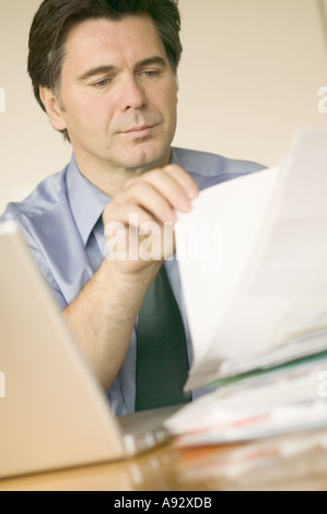 La fin de la quarantaine caucasien homme businessman avec pile de paperasse Banque D'Images