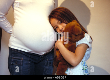 Fille à l'écoute de mère enceinte estomac s St Paul Minnesota Banque D'Images