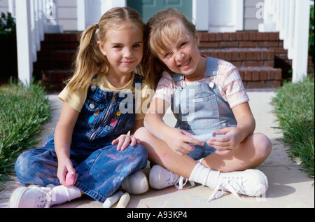 Portrait de deux jeunes filles siégeant ensemble Banque D'Images