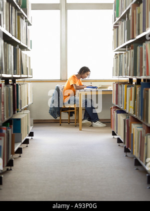 Teenage boy doing Homework in library Banque D'Images