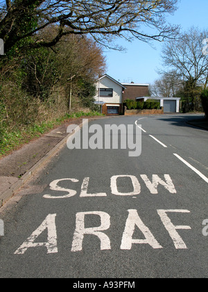 L'ARAF LENTE gallois bilingue anglais le marquage routier sur virage sur route à Newport South Wales UK Banque D'Images