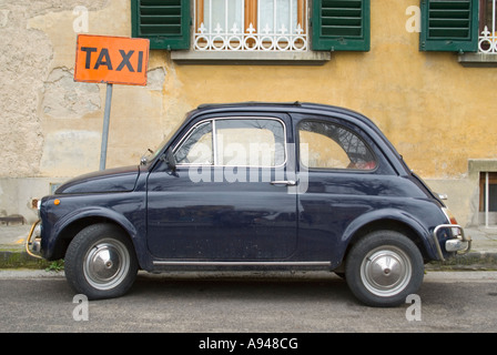 Horizontal comique close up of a classic Fiat 500 stationnée sur la route près d'une enseigne Banque D'Images