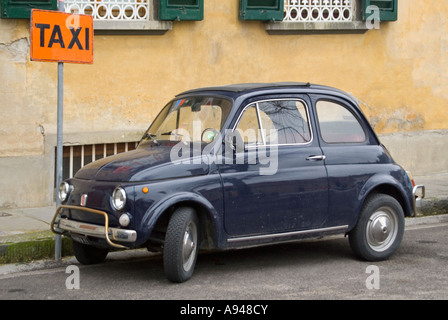 Horizontal comique close up of a classic Fiat 500 stationnée sur la route près d'une enseigne Banque D'Images