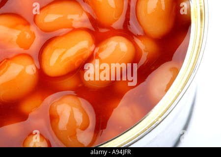 Ouverture du pot de élevée en fibres alimentaires des haricots blancs en sauce tomate isolé sur un fond blanc avec aucun peuple et un chemin de détourage Banque D'Images