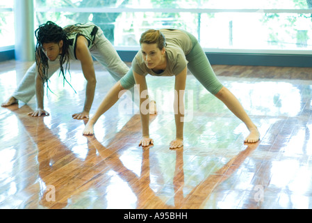 Deux jeunes adultes faire prasarita padottanasana posent en yoga class Banque D'Images