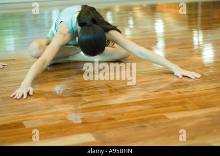 Jeune femme faisant coin vers l'avant au cours de classe d'exercice Banque D'Images