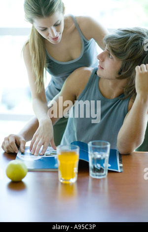 Les jeunes adultes en vêtements d'exercice ayant snack dans un club de santé à la cafétéria, au magazine Banque D'Images