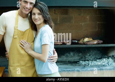 Couple having barbecue, smiling at camera Banque D'Images