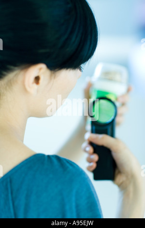 Woman inspecting packaged food avec loupe Banque D'Images