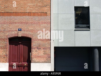 Close-up de deux façades de bâtiments, un en brique rouge et l'autre dans le béton Banque D'Images