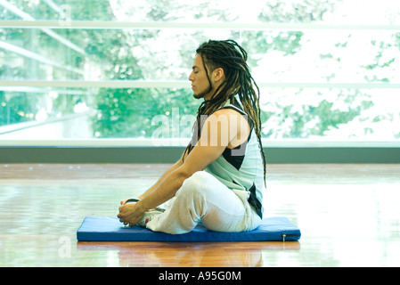 Homme assis en position du lotus, side view Banque D'Images