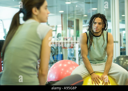 Deux jeunes adultes assis sur des boules de forme physique Banque D'Images