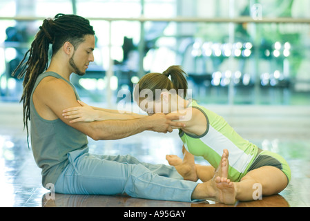 Instructeur d'exercice helping woman stretch Banque D'Images