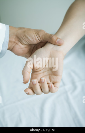 Prendre le pouls de la femme médecin, close-up Banque D'Images