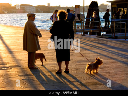 Deux femmes avec des chiens sur le plomb, Venise, Italie. Banque D'Images