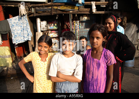 Enfants indiens posant à l'extérieur de maisons de taudis, d'Mello Road, Mumbai, Inde Banque D'Images