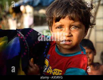 Jeune garçon indien posant à l'extérieur de la maison miteuse, d'Mello Road, Mumbai, Inde Banque D'Images