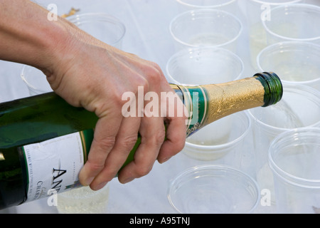 Détroit, Michigan Champagne est versé à partir d'une bouteille dans des gobelets en plastique Banque D'Images