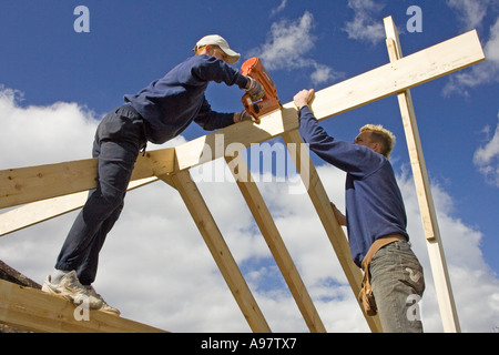 Contructing bâtisseurs d'un nouveau toit pour une extension d'une maison à l'aide d'un pistolet de scellement Banque D'Images