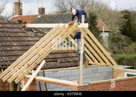 Contructing bâtisseurs d'un nouveau toit pour une extension d'une maison Banque D'Images