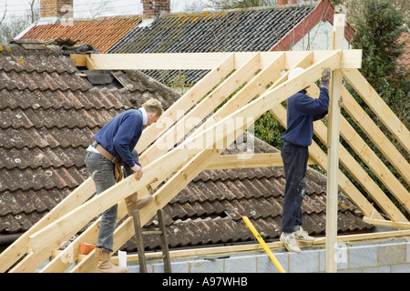 Ceux qui construisent un nouveau toit pour une extension d'une maison Banque D'Images