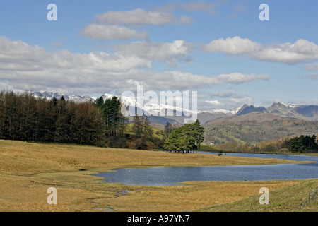 Vue sur Sage Een Tarn avec une montagne au loin dans le Parc National de Lake District Cumbria England Banque D'Images