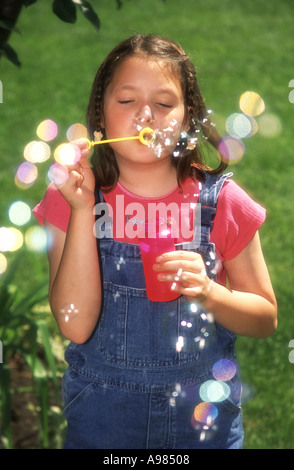 Huit ans girl blowing bubbles Banque D'Images