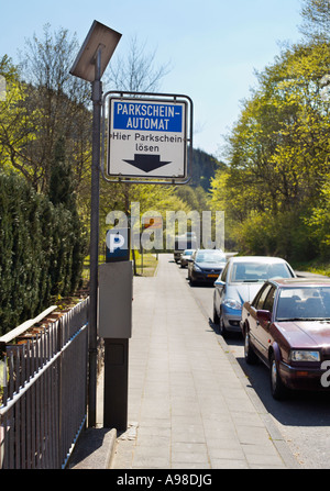 Parcomètre alimenté à l'énergie solaire avec des voitures garées dans la rue à l'intérieur de la zone de stationnement, l'Allemagne, de l'Europe Banque D'Images