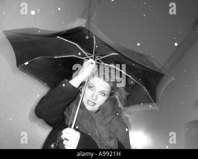 Une jolie femme forte batailles du vent et de la neige pendant une tempête hivernale dans la région de New Haven Connecticut USA Banque D'Images