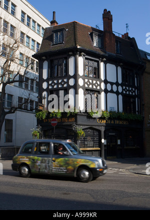 Taxi passe le 'Coach and horses" "olde worlde" ^pub dans 'Mayfair', Londres Banque D'Images