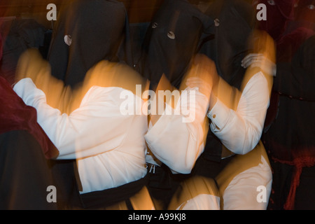 Les membres d'un capuchon fraternité religieuse porter des robes porter un flotteur pendant la Semaine Sainte, une procession, Bilbao, le nord de l'Espagne. Banque D'Images