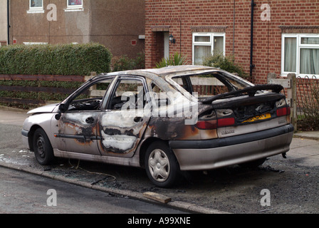 Voiture brûlée sur route à Coventry Banque D'Images