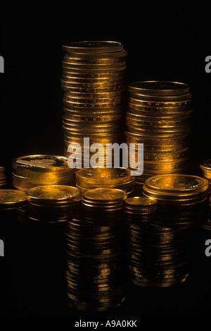 Des piles de pièces de monnaie de lingot d'or sur fond noir Banque D'Images