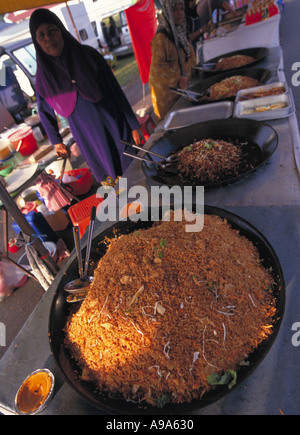 Cenang Langkawi Kedah Malaisie marché nuit vendeur femelle avec wok plein de nasi goreng un repas traditionnel plat de riz épicé Banque D'Images