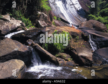 La Malaisie Kedah Langkawi Seventy Telaga Cascade de 7 puits avec chute d'une femme assis sur des pierres de soleil. Banque D'Images