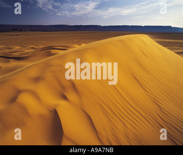 Le vent d'Or foncé avec des dunes de sable hills sur l'horizon sud Maroc Banque D'Images