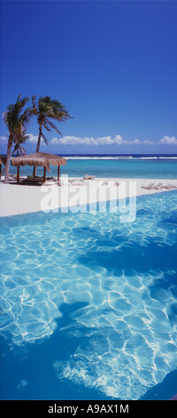 Le Mexique Péninsule du Yucatan Quintana Roo Cancun Riviera Maya palapas sur la plage par la mer avec piscine en premier plan Banque D'Images