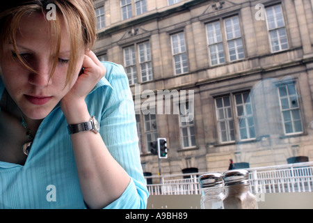 Une femme se lit dans cafe Banque D'Images
