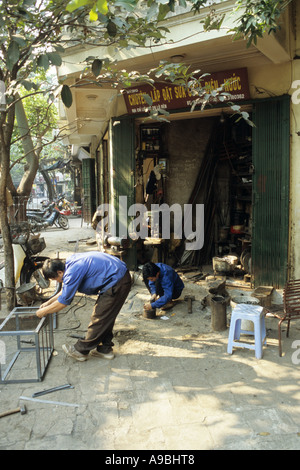 Les travailleurs du métal à un atelier de la chaussée dans Lo Ren St, vieux quartier de Hanoi, Viet Nam Banque D'Images