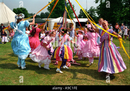 Les enfants danser autour du mât lors d'une foire d'été à Dulwich Park, Londres. Banque D'Images