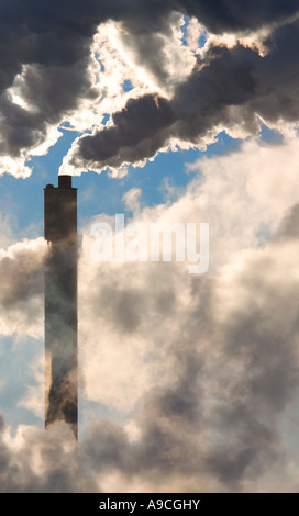 Fumkestack au milieu des nuages qui débordent de fumée noire , Finlande Banque D'Images