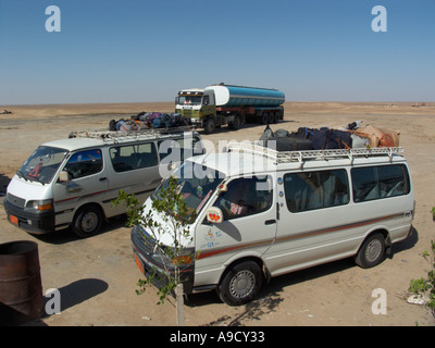 Les véhicules garés à touristes cafe à distance sur route au désert occidental de l'Égypte Banque D'Images