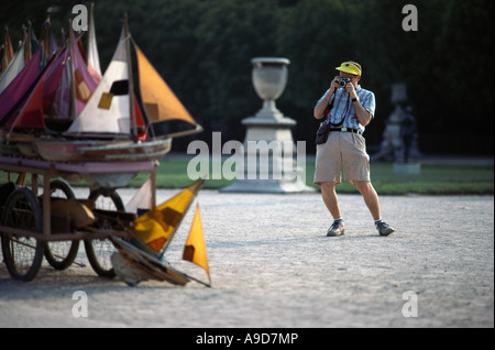 Paris France Un homme prenant une photo de bateaux modèles dans le jardin des Tuileries Banque D'Images