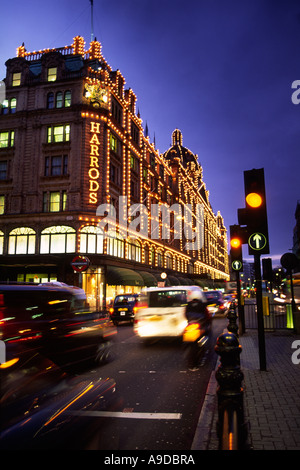 Le célèbre grand magasin Harrods allumé jusqu'au crépuscule dans la ville de Londres Angleterre Royaume-uni Banque D'Images