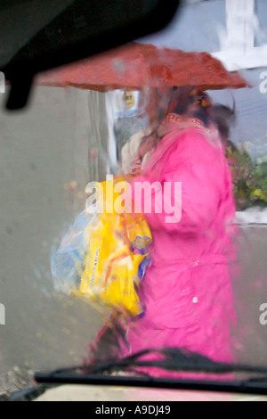 Départ de l'acheteur épicerie avec parapluie sous la pluie. Rzeczyca Pologne Banque D'Images