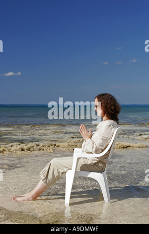 Femme méditant sur la plage Banque D'Images